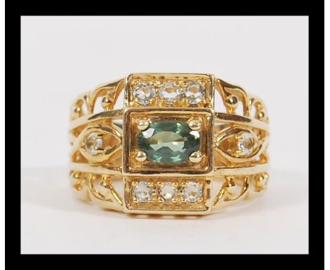 A vintage 20th Century hallmarked 9ct gold ring having large fret pierced shoulders with central faceted green stone flanked 