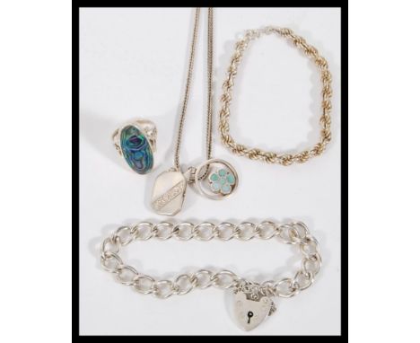 A collection of silver jewellery to include a a heart lock bracelet on a curb link chain, a rope bracelet on a spring ring cl