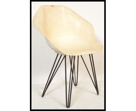 A vintage retro circa 1960's fibreglass tub chair in the manner of Arkana raised on ebonised hair pin supports.