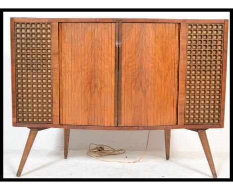 A 1950S DECCA STEREOGRAM in walnut case, with semi-bow front tambour doors to the centre flanked by honeycomb speaker grills 