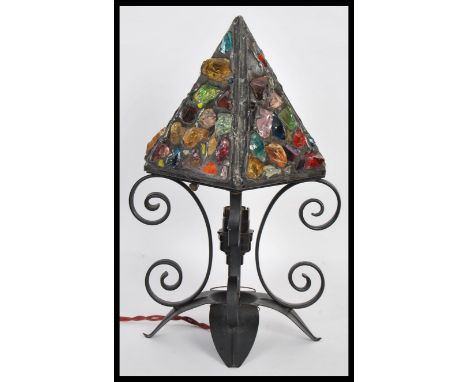A 20th Century iron scrollwork table lamp, the lamp raised on four downward swept leaf base with scrollwork above surmounted 