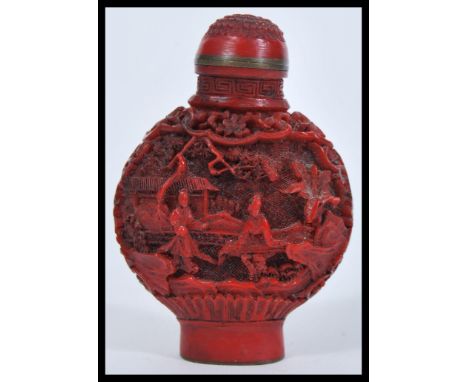 A 19th Century Chinese Cinnabar lacquer snuff bottle of moon flask shape having decoration depicting figures in the Canton st