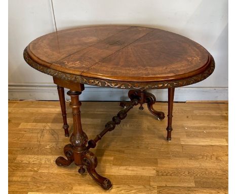 A 19th century walnut Sutherland table, profusely inlaid throughout with turned and intricate carved details, standing on cab