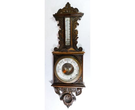 An Edwardian carved oak wall barometer 