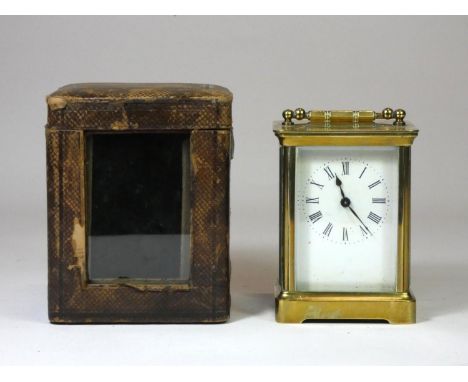 A brass cased carriage clock, four bevelled glazed sides with balance wheel window, white enamel dial with painted Roman nume
