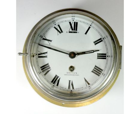 A Smith's bulkhead clock, brass case with painted enamel dial, roman numerals, dial also shows Smiths's Cricklewood NW2, made