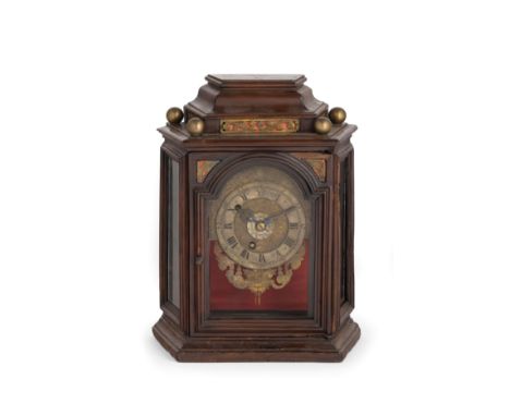 Pendola a struttura architettonica in legno di noce. Nella trabeazione un fregio fitomorfo in bronzo dorato; pinnacoli a sfer