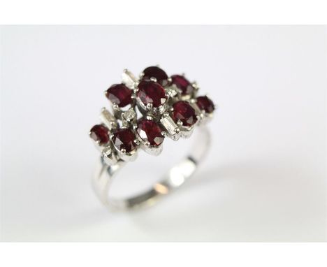 A Lady's Vintage 14ct White Gold, Ruby and Diamond Cluster Ring. The ring set with nine oval rubies one 5 x 4mm four 4.3 x 4.