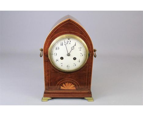 An Edwardian Mahogany Mantel Clock. An Oak Gothic arch case with decorative inlay, white enamel face and Arabic numerals, rai