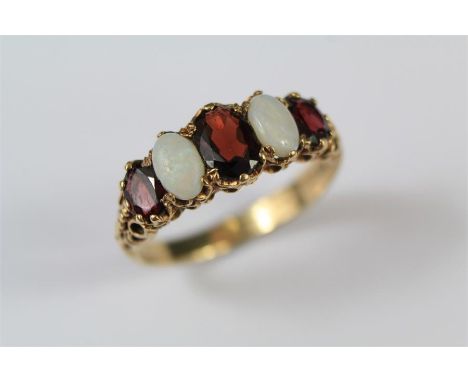 A 9ct Yellow Gold, Opal and Garnet Ring. The ring set with an oval garnet approx 8 x 5mm, ring size T, approx 3.9 gms.