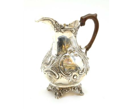 A Victorian silver milk jug, By Charles Boyton, London, 1863, of baluster form with embossed foliate scroll decoration, raise