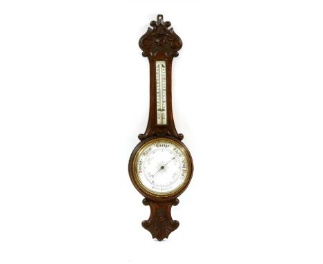 A carved oak aneroid barometer