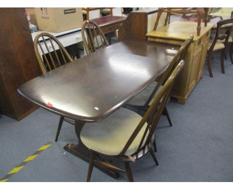 An Ercol dining table on pedestal base together with four Ercol spindle backed dining chairs 