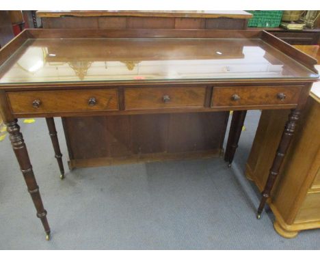 A Georgian mahogany serving table with galleried to, having three small drawers on ring turned legs above castors 92 x 121 x 
