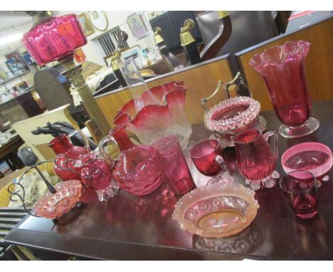 A Victorian oil lamp with cranberry glass reservoir, a glass funnel and clear glass with cranberry edged shade together with 