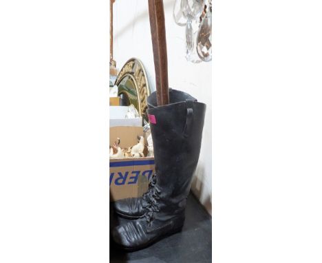 A composition stick stand in the form of a pair of boots, the lot to include two walking sticks