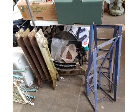 A pair of car ramps, a metal radiator, stainless steel paddle, metal fire grate and front