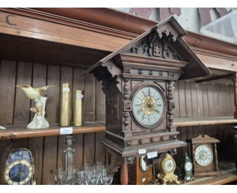 A 19th century cuckoo clock with brass weights and a ceramic bird figure