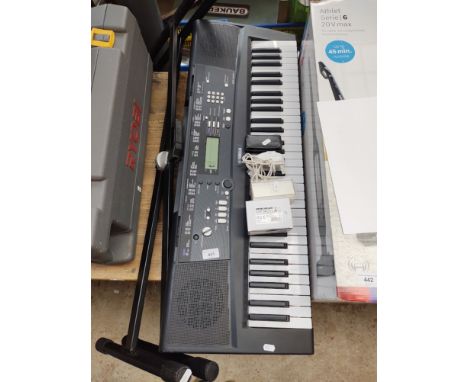 A Yamah EZ220 keyboard with stand and power lead, together with an ipod nano with charger and original packing