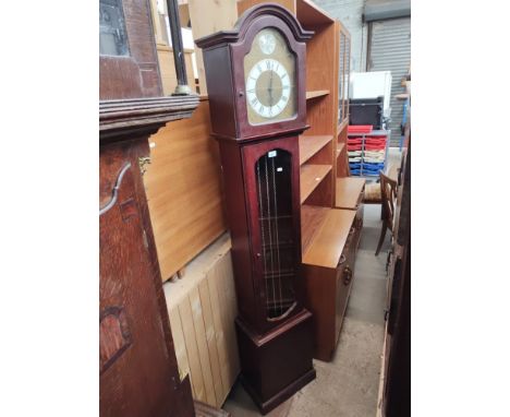 A chiming mahogany grandfather clock with brass dial, weights and pendulum.