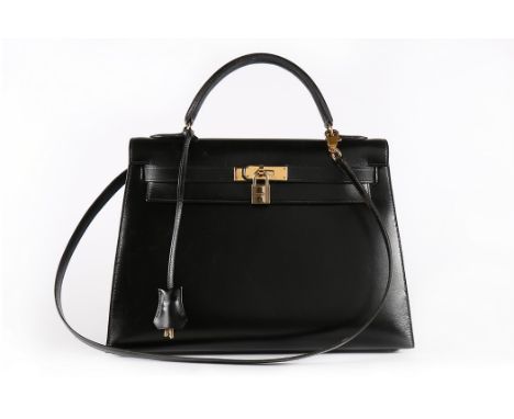 A good Hermès black leather Kelly bag, 1992, blind stamp V, with gold-plated metal hardware, padlock, keys, and detachable sh