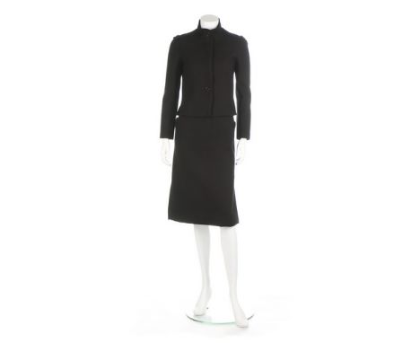 An André Courrèges black wool suit, circa 1970, Paris labelled and 00, the jacket with concealed button fastening and epaulet