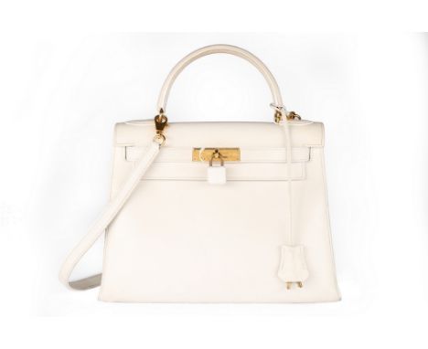 An Hermès off-white leather Kelly bag, 1991, blind stamp U, with gold-plated hardware, leather covered padlock, fob and keys,