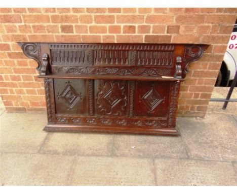 A SECTION OF CARVED OAK PANELLING  with foliate and lozenge decoration and shelf supported on carved corbels, 162cm wide 81cm