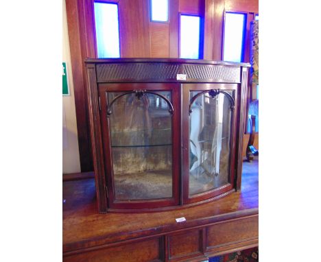 AN EDWARDIAN CARVED MAHOGANY BOW FRONT GLAZED CABINET,  the plush lined interior fitted with glass shelf, 72cm wide 45cm deep