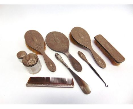 A FOUR PIECE SILVER DRESSING TABLE SET comprising a hand mirror, and three brushes; with two silver mounted glass toilet bott