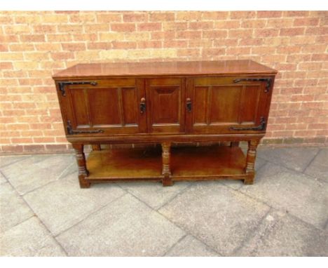 A LARGE OAK SIDEBOARD,  with pair of doors with large decorative iron hinges, on turned supports above pot shelf, 153cm wide 