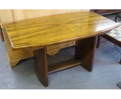 ART DECO FIGURED WALNUT DINNING TABLE, THE SHAPED RECTANGULAR TOP WITH CARVED DETAIL TO THE ENDS AND SLAB SUPORRTS, TIED BY A