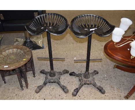 A pair of bar stools with tractor style seats
