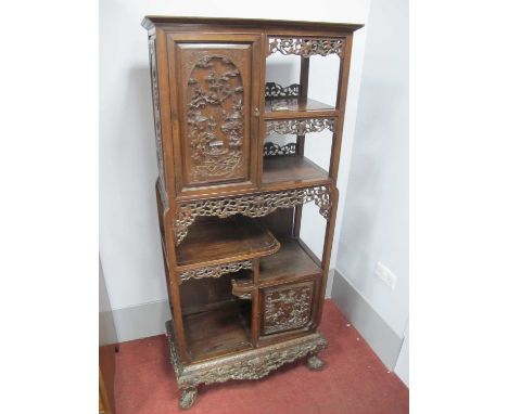 A XX Century Chinese Hardwood Cabinet, the upper and lower sections each with open shelves and cupboard doors carved with myt