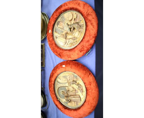 A pair of continental ceramic plaques, decorated figures in a cellar, in red velvet frames, 12" dia 