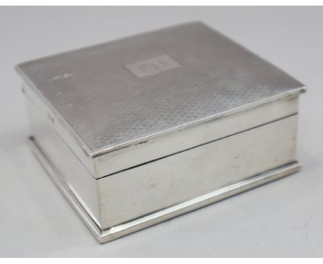 A silver cigarette box with engine turned lid and a pair of engine turned silver backed clothes brushes