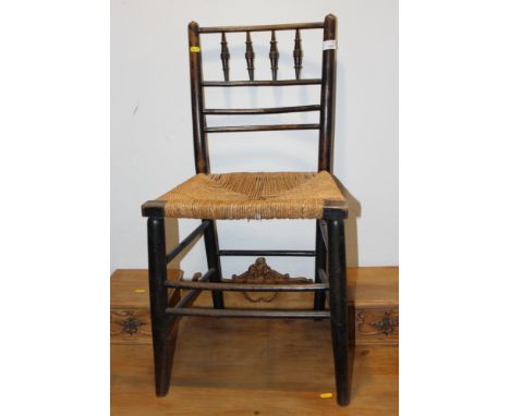 An ebonised frame Sussex chair with string seat