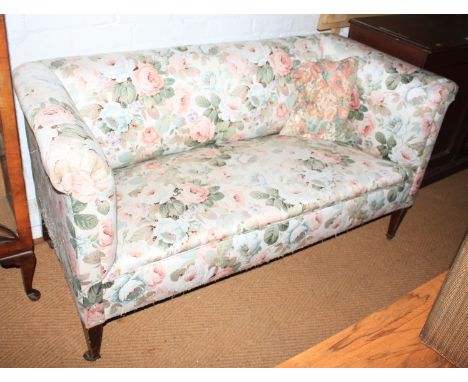 A late 19th century two-seat settee, upholstered in a floral fabric, on square tapering supports, 60" wide