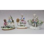A 19th century Meissen figure of a seated woman with a birdcage, 5 1/2" high, a figure of a cherub