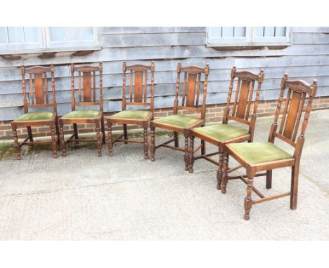 A set of six oak panel back dining chairs with green velvet drop-in seats, on turned and stretchered supports