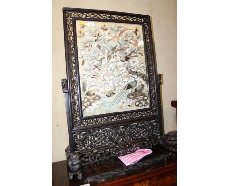 A late 19th century Chinese carved hardwood fire screen with bird embroidered panel, on splay supports, 32 ½” high x 24” wide