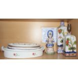 A tin-glazed double table salt, formed as figures holding baskets, two plates, a table lamp, a