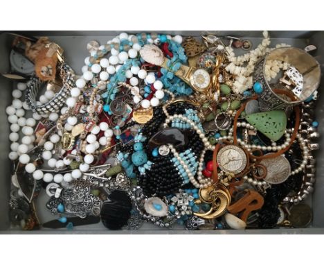 A metal box containing assorted vintage costume jewellery.  