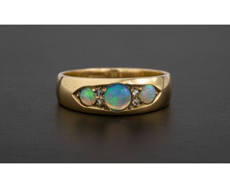 A Victorian 18ct gold, water opal and diamond ring set with three graduated round cabochon opals divided by pairs of rose cut