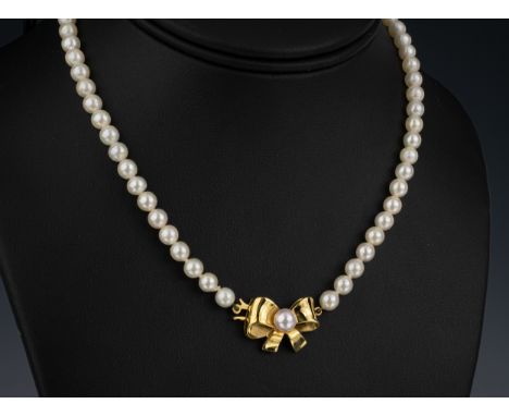 A single strand cultured pearl necklace with 5mm. pearls and 9ct gold pearl set bow clasp, 15in. (38cm.) long.  