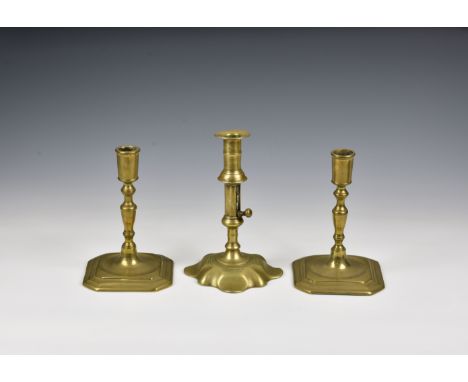 A closely matched pair of George I cast brass candlesticks with tapered cylindrical nozzles, turned tapered stems and slightl