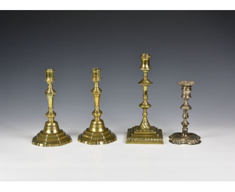 A pair of George II brass candlesticks c.1750, the octagonal waisted sconces and tapered stems on stepped, octagonal bases wi