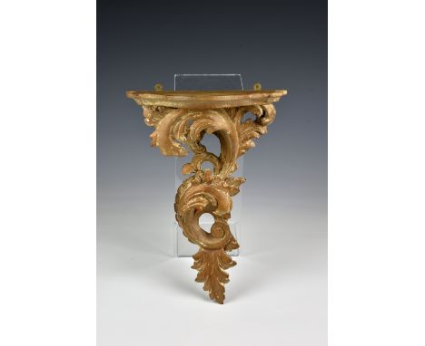 An 19th century carved limewood rococo style foliate wall bracket traces of gilding to reverse, with serpentine shelf, 12½in.