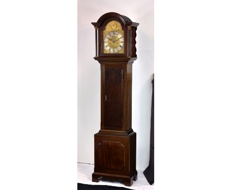 A late Victorian eight day longcase clock the eight day movement striking the hours on a gong, fronted by an arched brass dia