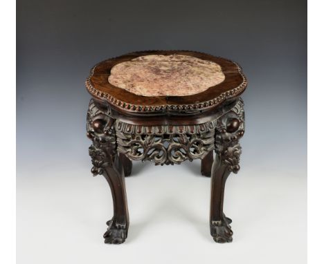 A Chinese carved hardwood low jardinière stand late 19th, early 20th century, with inset shaped rouge marble top and carved p